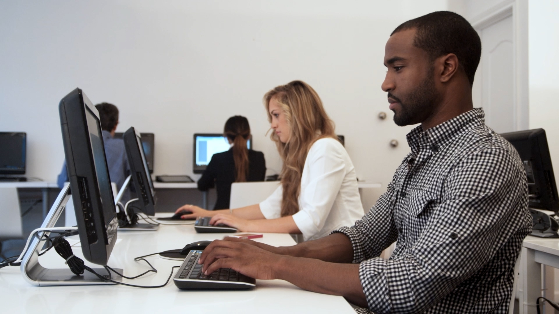 man and woman at computer workstations